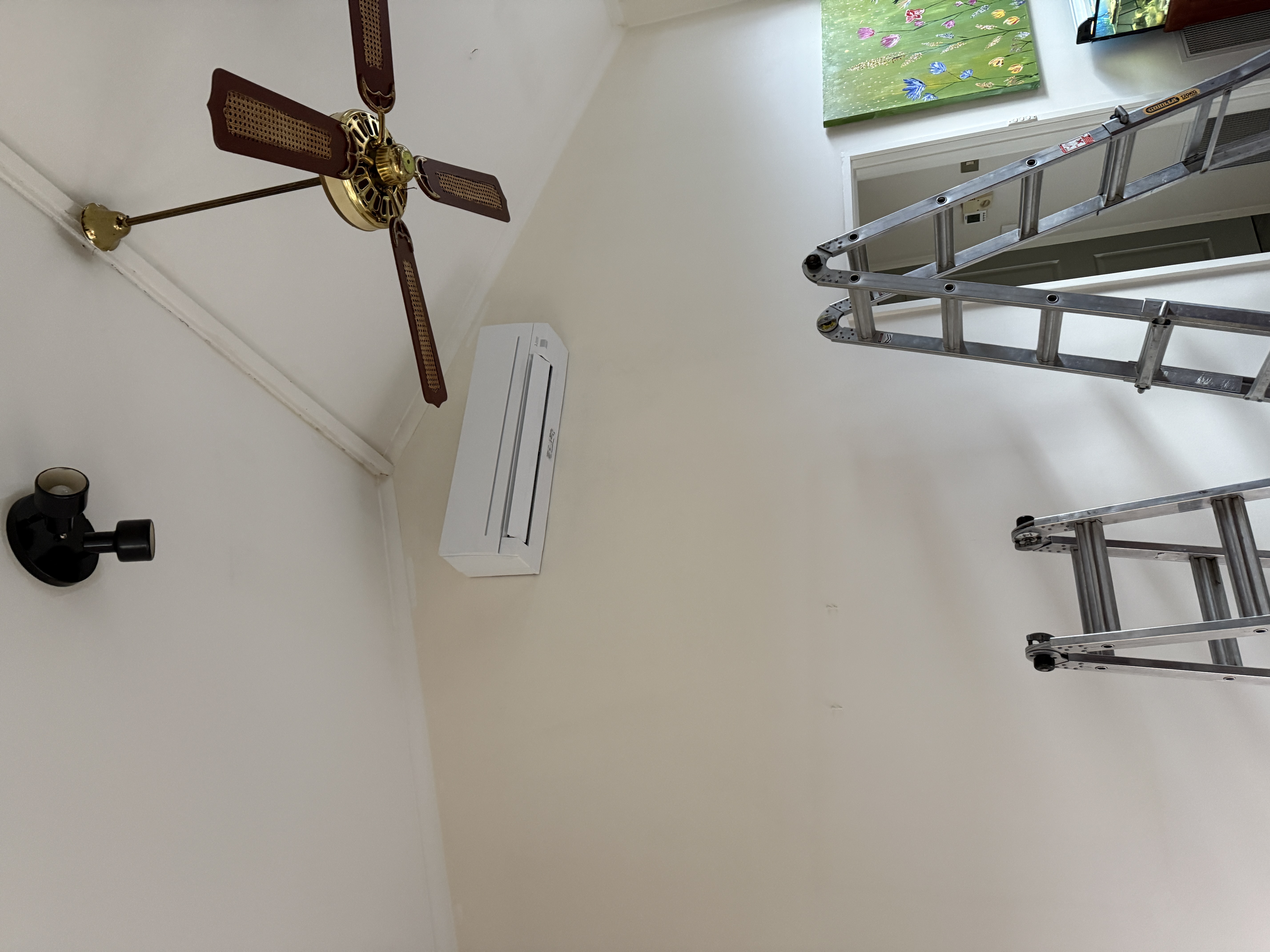 Indoor wall-mounted split system above ladders in a living room