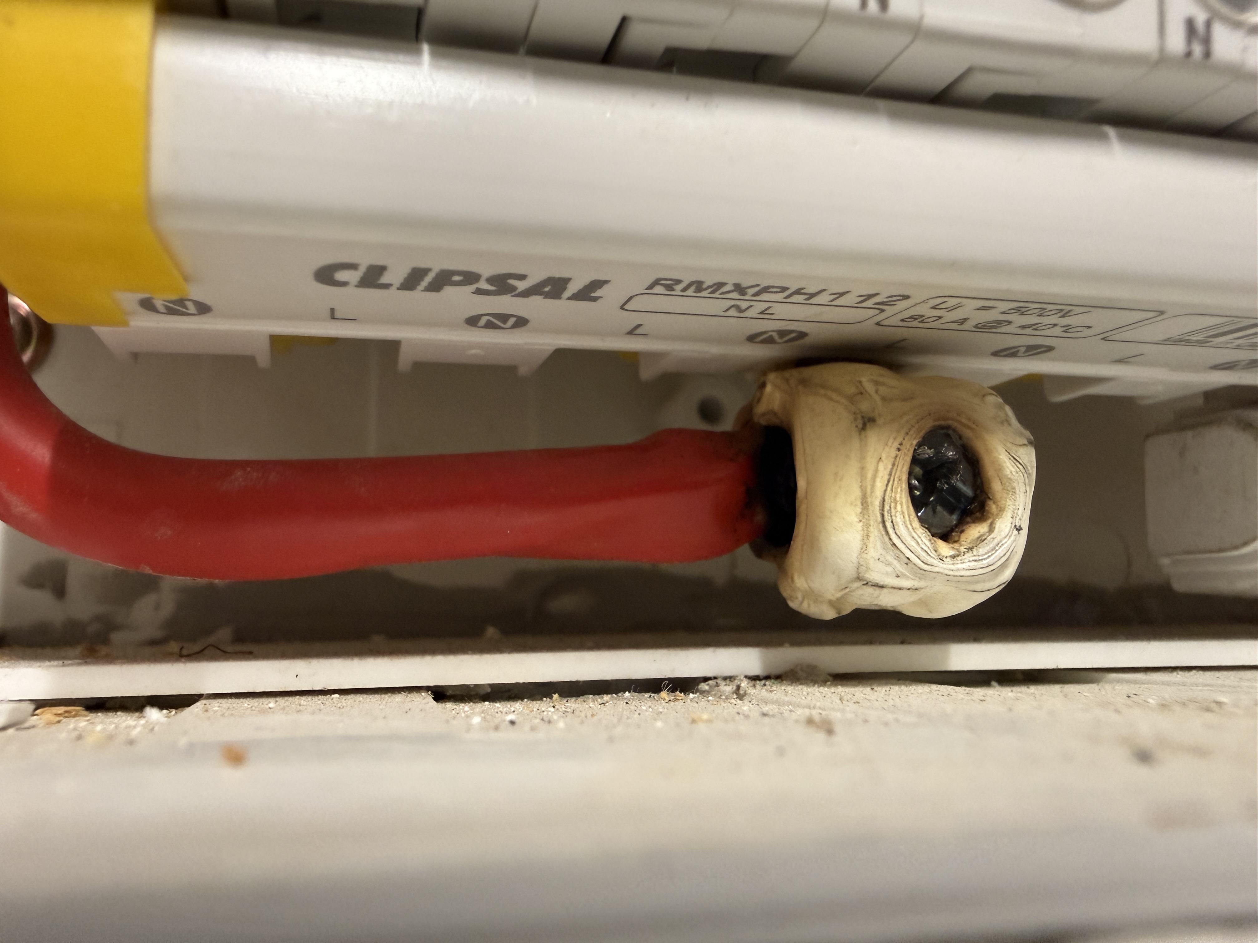Melted and scorched electrical switchboard terminal connector showing dangerous overheating hazard